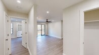 Located in the Briar Knoll community of Toms River, NJ, this thoughtfully renovated single-floor residence offers a clean, contemporary aesthetic throughout. Light-toned luxury vinyl plank flooring flows seamlessly across every room, complementing the crisp white walls and recessed lighting that create a bright, welcoming atmosphere.

The open living area is anchored by a ceiling fan with a sleek wood-finish and features sliding glass doors that lead to a private balcony, offering tranquil views of a lush wooded landscape. The kitchen is a standout, showcasing a two-tone cabinet design with bright white upper cabinets and deep espresso-toned lower cabinets, paired with stainless steel appliances including a refrigerator, range, and dishwasher. A window above the sink brings in natural light.

The bedrooms are well-proportioned and include generous closet space with built-in shelving and rods. A programmable thermostat is conveniently mounted in the hallway, which connects the rooms with ease. The bathroom features a soaking tub with a designer tile surround — large-format concrete-look tiles flanking a striking vertical chevron mosaic accent strip — finished with brushed nickel fixtures for an elevated, modern touch.