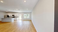 Located in Ocala, Florida, this two-story home offers a well-designed layout spread across two floors. The exterior presents a clean, modern aesthetic with blue-gray siding, a wide concrete driveway, and an attached two-car garage, set within a neatly landscaped neighborhood.

The main floor hosts a bright, open-concept kitchen and living area with warm wood-look flooring throughout. The kitchen is a standout feature, showcasing white shaker-style cabinetry, granite countertops, stainless steel appliances, and a large central island with a built-in sink — ideal for both cooking and entertaining. The living room benefits from natural light via side windows. A dedicated laundry room on this level includes a full-size washer and dryer with overhead wire shelving.

Upstairs, two spacious bedrooms are finished with plush carpeting and ceiling fans. The generously sized primary bedroom features vaulted ceilings and large windows with outdoor views, accompanied by a walk-in closet outfitted with wire shelving systems. The home includes three bathrooms, each featuring granite-topped vanities and wood-look flooring; one includes a tub-shower combo. Two closets and a staircase complete the functional, efficiently organized floor plan.