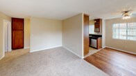 Located at 750 Paseo De Luz in Chula Vista, this single-story unit offers a practical and comfortable layout with a neutral color palette of warm beige tones throughout. The living area features a combination of plush carpeting and tile flooring, with natural light streaming in through a sliding glass door that leads to a private balcony. An open sightline connects the living space to the kitchen, which is equipped with stainless steel appliances including a gas range, over-the-range microwave, and a double-basin sink. Warm-toned wood cabinetry pairs with dark granite countertops, creating a functional and attractive cooking space with a window providing additional natural light.

The bedrooms are generously sized, each featuring soft carpeting and windows that bring in outdoor greenery views. The primary bathroom includes a granite-topped vanity with an undermount sink, a large framed mirror, and a separate water closet with a shower-tub combination. A second full bathroom also features a shower-tub combo with clean white surrounds and tile flooring. The overall layout, as reflected in the floor plan, is well-organized and efficiently designed for comfortable single-floor living.