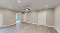 Located at 2121 Langhorne Rd in Lynchburg, Virginia, this single-story, 3-bedroom, 2-bathroom home offers a clean, modern aesthetic throughout. Light-toned luxury vinyl plank flooring runs through the main living areas, complemented by neutral gray walls and crisp white trim that create a bright, cohesive atmosphere. Recessed lighting and ceiling fans are featured in multiple rooms, enhancing both comfort and functionality.

The kitchen stands out with its gray shaker-style cabinetry, white quartz countertops, white subway tile backsplash, and stainless steel appliances including a range and over-the-range microwave. The spacious primary bedroom features recessed lighting, a ceiling fan, and access to an adjoining room, offering a comfortable and private retreat. Additional bedrooms are carpeted and receive natural light through well-placed windows, each equipped with ceiling fans.

The bathrooms are finished in a clean, contemporary style, featuring tub-shower combinations with white surrounds, gray vanity cabinetry, and light flooring. A dedicated laundry room houses a full-size washer and dryer with overhead shelving for added storage convenience. The home's efficient, single-floor layout provides a practical and comfortable living environment throughout.