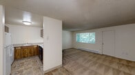 Located at 9900 SW Conestoga Dr in Beaverton, Oregon, this single-floor, one-bedroom, one-bathroom residence offers a practical and comfortable layout. The entrance leads into an open living and dining area highlighted by a charming stone-surround fireplace, a large window that frames views of surrounding greenery, and a baseboard heating system. Plush carpeting throughout the living areas adds warmth, while durable tile flooring defines the kitchen and entrance zones.

The kitchen is thoughtfully arranged in a U-shaped configuration, featuring warm wood cabinetry, light-toned countertops, a full suite of white appliances including a refrigerator, dishwasher, and electric range, and a tile floor that complements the rest of the space.

The bedroom offers a comfortable retreat with carpeted flooring, a window for natural light, baseboard heating, and a ceiling fan. A set of sliding-door closets provides generous storage, and additional closet space is available throughout the unit — totaling three closets.

The bathroom is clean and functional, featuring tile flooring, a wood-cabinet vanity with a single sink, and a full tub-shower combination. A textured ceiling is present throughout the home, lending a consistent, classic character to every room.