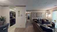 Located at 4236 Austell Rd in Austell, Georgia, this single-floor residence offers a thoughtfully designed layout that balances comfort and functionality. The open-concept living and dining area is anchored by wood-style flooring, a textured ceiling, and a large sliding glass door that floods the space with natural light and provides direct access to a private balcony with outdoor views. The living room features ample space for seating arrangements and is accented by framed wall art and crown molding details.

The galley-style kitchen is efficiently designed with dark cabinetry, granite-style countertops, a tile backsplash, and black appliances including a refrigerator, electric range, microwave, and dishwasher. Light wood-style flooring runs throughout the kitchen, which connects conveniently to a utility area.

The primary bedroom is generously sized with plush carpeting, a ceiling fan, and two closets offering abundant storage. A secondary bedroom also features carpet flooring, a dedicated closet, and a built-in desk area, making it ideal for a guest room or home office. The bathroom is finished with dark wood vanity cabinetry, granite-style countertops, wood-style flooring, and a shower/tub combination.