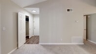This single-story home offers a thoughtfully arranged floor plan with 2 bedrooms, 4 bathrooms, two closets, and a combined kitchen and living area. Neutral warm-beige walls and white trim are consistent throughout, creating a cohesive and clean aesthetic. Flooring transitions purposefully between durable wood-look vinyl in the kitchen, bathrooms, and hallway, and soft wall-to-wall carpeting in the bedrooms and living areas.

The kitchen features white cabinetry, a granite-look countertop with an integrated sink, white appliances including a range, microwave, and refrigerator, and a peninsula that opens toward the living space. The bedrooms are carpeted, with neutral walls and ample natural light from windows overlooking greenery. The primary bedroom includes a ceiling fan and light fixture, while both bedrooms provide access to dedicated closet space.

The bathrooms are finished with clean white tub-shower combinations, wood-look vinyl flooring, and granite-look countertops at the vanities, accented by large mirrors and well-lit fixtures with chrome hardware. A central hallway connects the main living areas to the bedrooms and bathrooms, enhancing the flow of the space. The overall design is practical, consistent, and move-in ready.