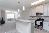 Located at 5301 Williamsburg Station Ln in Greensboro, NC, this single-floor home offers a thoughtfully designed layout with a neutral color palette and a clean, contemporary aesthetic throughout. The kitchen is a functional highlight, featuring stainless steel appliances, white shaker-style cabinetry, granite countertops, a classic subway tile backsplash, and light hardwood-style flooring that adds warmth to the space. A pantry with built-in shelving provides generous storage.

The living area is carpeted and well-proportioned, with crown molding, a ceiling fan, and a window fitted with plantation shutters that allow for controlled natural light. The space transitions smoothly into a dining area near the front entry, which features light wood-style flooring and a wall-mounted thermostat for convenience.

The bedroom is carpeted and bright, benefiting from a ceiling fan and a window that brings in natural light. It connects to a spacious walk-in closet outfitted with wire shelving and hanging rods across multiple walls. The bathroom includes a full tub-shower combination with a curtain rod and tile flooring. A dedicated laundry room with washer/dryer hookups, built-in shelving, and tile flooring rounds out the home's practical offerings.
