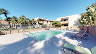 Located at 10139 Woodley Ave in the North Hills neighborhood of Los Angeles, this outdoor amenity space captures the essence of Southern California living. The centerpiece is a generously sized rectangular swimming pool with crystal-clear water, framed by a smooth concrete sundeck that offers ample space for lounging. Multiple reclining lounge chairs and colorful seating are arranged poolside, inviting relaxation under the abundant California sunshine.

The pool area is enclosed by a textured masonry block wall, providing privacy while maintaining an open, airy feel. Beyond the perimeter wall, a diverse collection of mature trees — including tall palms, cypresses, and broad-canopy shade trees — creates a lush, verdant backdrop that enhances the resort-like atmosphere.

A separate patio area features an outdoor dining table with colorful chairs, set against the backdrop of the property's stucco building with a pitched roof and large glass entryway. Decorative potted plants and mature landscaping frame the entrance, adding warmth and character to the space.

The surrounding multi-story buildings, finished in warm earth tones, complete the cohesive architectural aesthetic. With abundant natural light, thoughtful greenery, and well-maintained outdoor furnishings, this space offers an inviting and functional outdoor retreat.