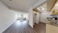 Located on Yorba Linda Blvd in Fullerton, CA, this one-bedroom, one-bathroom unit offers a thoughtfully organized single-floor layout. The living room is generously proportioned, featuring dark hardwood-style flooring, crisp white walls, and a textured ceiling that adds character throughout. Natural light fills the space through large windows dressed with vertical blinds, creating a bright and airy atmosphere. A wall-mounted A/C unit provides climate control directly in the living area.

The dining room connects seamlessly to the living space, supporting an open and functional flow. The kitchen is efficiently designed with granite-style countertops, light wood cabinetry, a range, and overhead ventilation — offering practical storage and workspace. An additional built-in storage cabinet is situated near the kitchen entry.

The bedroom is a well-sized retreat featuring the same hardwood-style flooring, a window with natural light, and a full-width sliding closet with built-in shelving for ample storage. The bathroom continues the warm aesthetic with granite countertops, a light wood vanity, an overhead mirror with lighting, and a shower/tub combination. A hallway with track lighting connects the rooms, completing this cohesive and efficiently designed unit.