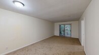 This well-appointed 2-bedroom, 2-bathroom residence in Winston-Salem, NC offers a practical and comfortable single-floor layout. The combined dining and living area serves as the heart of the home, featuring soft neutral-toned carpeting and a sliding glass door fitted with vertical blinds that opens to an outdoor view of lush greenery, allowing natural light to fill the space. The kitchen is thoughtfully designed with white shaker-style cabinetry, light granite-look countertops, warm hardwood-style flooring, and stainless steel appliances including an electric range and dishwasher. A pass-through window connects the kitchen to the living area, enhancing the open feel. Both bedrooms are carpeted and finished in soft neutral tones, each with windows that bring in natural light and views of the surrounding greenery. The primary bedroom offers a generous footprint with dedicated closet access. The two bathrooms are clean and functional — one featuring a white vanity with under-cabinet storage and a mirror above, the other showcasing a full soaking tub with a shower combo and built-in wall niches. Four closets throughout the home provide ample storage for everyday living.
