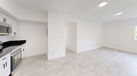 Located at 147 NW 59th St, Unit 306 in Miami's vibrant Little Haiti neighborhood, this spacious 5-bedroom, 2-bathroom unit offers a well-designed, single-floor layout ideal for shared or multi-use living. The unit features two fully equipped kitchens, each outfitted with sleek white cabinetry, dark granite countertops, and a complete suite of stainless steel appliances including a refrigerator, range, microwave, and dishwasher. Light-toned large-format tile flooring runs consistently throughout, creating a clean and cohesive aesthetic. The five bedrooms are bright and minimalist, with crisp white walls and ample natural light. Several rooms include sliding closet doors for practical storage, while select bedrooms offer serene treetop views through large windows. Two hallways connect the rooms efficiently, maintaining a logical flow throughout the unit. Both bathrooms share a striking design featuring floor-to-ceiling dark slate tile in open walk-in showers, contrasted by white vanities and light tile floors. The overall ambiance is modern, clean, and move-in ready, with a neutral palette that offers flexibility for any furnishing style. The thoughtful layout and dual-kitchen configuration make this unit especially well-suited for co-living or group occupancy.