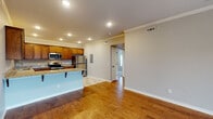 Located at 7484 Peony Pl in Springdale, Arkansas, this single-story home presents a well-designed layout with a comfortable and functional interior. The open-concept living and kitchen area serves as the centerpiece of the home, featuring warm hardwood flooring that extends throughout the main living spaces. Crown molding adds a refined architectural detail, while recessed lighting and ceiling fans provide both practicality and style.

The kitchen is well-appointed with rich wood cabinetry, granite countertops, and a full suite of stainless steel appliances, including a refrigerator, range, and microwave. A breakfast bar peninsula offers additional counter space and casual seating, seamlessly connecting the kitchen to the living area. The living room includes French doors that invite natural light and provide outdoor access.

The bedrooms feature plush carpeting, ceiling fans with light fixtures, and windows with blinds that allow for natural light while maintaining privacy. The bathrooms are finished with tile flooring, wood vanities topped with granite, oil-rubbed bronze fixtures, and tub-shower combinations, providing a clean and cohesive aesthetic throughout.