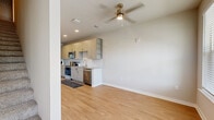 This two-story home offers a thoughtfully designed layout spread across two floors. The main level features an open-concept kitchen and living area with warm hardwood-style flooring, ceiling fans, and large windows that invite natural light. The kitchen is outfitted with crisp white shaker cabinetry, granite countertops, a subway tile backsplash, stainless steel appliances including a range, over-the-range microwave, and dishwasher. A door with sidelight windows on the main level provides direct outdoor access and additional natural light.

The upper level hosts both bedrooms, each carpeted and featuring ceiling fans, windows with views of the surrounding area, and generous closet space. The spacious primary bedroom includes a walk-in closet with wire shelving and dedicated hanging rods. Three bathrooms serve the home, including one featuring a soaking tub with marble-style surround walls and brushed nickel grab bars. Additional bathrooms offer granite-topped vanities with taupe cabinetry, mirrored storage, and hardwood-style flooring. Hallways and staircases connect the levels seamlessly, while two closets provide practical storage throughout. The home's neutral color palette and consistent finishes create a clean, cohesive aesthetic.