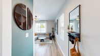 Located at 1755 Slaughter Rd in Huntsville, Alabama, this well-designed single-story home offers a thoughtful layout that maximizes its intimate footprint. Light wood-look flooring flows throughout, tying together each space with a warm, cohesive aesthetic.

The entry hallway makes an immediate impression, featuring a bold teal accent wall adorned with decorative artwork, setting a stylish tone that carries through the home. The open-concept living area is bathed in natural light from multiple large windows with white blinds and curtains, creating a bright and welcoming atmosphere. A ceiling fan adds comfort to the space.

The kitchen is a standout, showcasing crisp white shaker cabinets, granite countertops, stainless steel appliances including a refrigerator with ice maker, range, microwave, and dishwasher, and a breakfast bar for casual dining. A sliding glass door opens directly to a private outdoor patio, allowing for seamless indoor-outdoor living.

The bedroom is a serene retreat, highlighted by a deep navy blue accent wall, natural light from a window with sheer curtains, and a closet with built-in shelving. The full bathroom features granite countertops, white cabinetry, and a shower-tub combination with a window for natural light. Every detail reflects a clean, modern design sensibility.
