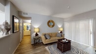 This single-floor residence offers a thoughtfully designed layout that balances comfort and functionality across its living spaces. The living room serves as the heart of the home, featuring warm wood-look flooring, neutral walls, and large sliding glass doors with vertical blinds that invite natural light and provide access to the outdoors. The space accommodates both a seating and entertainment area with ease.

Adjacent to the living room, a dedicated dining area is brightened by a window and offers an intimate setting for meals. The galley-style kitchen is well-equipped with white cabinetry, generous counter space featuring light stone surfaces, a double stainless steel sink, and full appliances including a gas range, refrigerator, and microwave.

The primary bedroom is a restful retreat with plush carpeting, a ceiling fan, and a large window. A second bedroom offers similar comfort and style. The full bathroom is clean and functional, featuring a tiled shower-tub combination, wood-look flooring, and crisp white fixtures.

A dedicated laundry room with a full-size washer and dryer adds everyday convenience. Throughout the residence, a consistent neutral palette and cohesive design create a calm, welcoming ambiance suited to a variety of lifestyles.