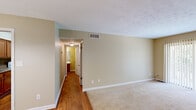 Located at 1246 Mooty Bridge Rd in LaGrange, Georgia, this well-appointed single-floor, one-bedroom, one-bathroom home offers a practical and comfortable layout across its thoughtfully organized rooms. Warm-toned hardwood floors run through the main living areas, including the dining room, kitchen, hallway, and bathroom, while plush carpet adds comfort to the living room and bedroom.

The living room is a welcoming space featuring a sliding glass door dressed with vertical blinds that floods the room with natural light and offers views of the surrounding greenery. The dining area is defined by a stylish multi-light chandelier that anchors the space, complementing the rich hardwood flooring beneath.

The kitchen is efficiently laid out with warm wood cabinetry, granite-style countertops, a stainless steel sink, and white appliances including a range and refrigerator. A tile backsplash adds a clean, finished touch to the cooking space.

The bedroom is a comfortably sized retreat with soft carpeting and its own sliding glass door providing additional natural light and outdoor views. The full bathroom features a tub-shower combination with white tile surround, a single vanity with a white countertop, and hardwood flooring. A hallway with a closet connects the private areas of the home, completing this functional and inviting layout.