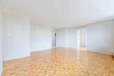 Located at 6161 Bathurst Street in North York, Toronto, this 3-bedroom, 1-bathroom unit offers a practical and well-laid-out floor plan across a single level. Classic parquet wood flooring runs throughout the living areas and bedrooms, lending warmth and a timeless character to the space. The generously sized primary bedroom is bathed in natural light through large floor-to-ceiling windows that frame views of the surrounding North York skyline and green spaces, with baseboard heating running beneath the windows. The two additional bedrooms are similarly bright, each featuring parquet flooring and windows that invite natural light. The kitchen has been updated with grey cabinetry, light granite-style countertops, a double sink, and marble-effect tile flooring, providing a clean and functional cooking space with ample storage. The bathroom features a full-size soaker tub and shower combination, finished with white subway-style wall tiles and chrome fixtures for a clean, classic look. A dedicated closet provides additional storage. The open living area connects seamlessly to the kitchen and bedrooms, creating a cohesive and easy-to-navigate layout. The unit's bright, neutral palette and consistent flooring throughout give it a unified and welcoming ambiance.
