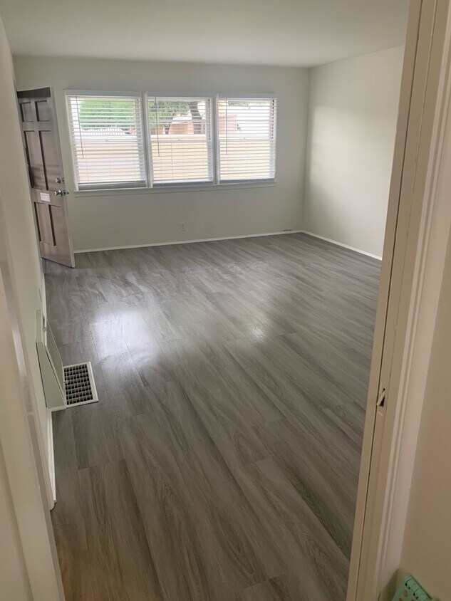 Large living room with new flooring throughout the unit, done in spring 2023. - 130 S Del Mar Ave