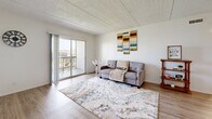 Located at 5518 Terrace Ct in Temple Terrace, FL, this single-floor, 2-bedroom, 1-bathroom home offers a well-organized layout with a clean, neutral aesthetic throughout. The living room features wood-look laminate flooring and a sliding glass door that opens to a private balcony, filling the space with natural light and providing outdoor views. Adjacent to the living area, the kitchen is equipped with stainless steel appliances, granite countertops, white cabinetry, and a convenient breakfast bar with seating for two — ideal for casual dining. Both bedrooms are carpeted for comfort and feature ceiling fans with light fixtures. The primary bedroom includes a set of bi-fold closet doors offering ample storage space. The second bedroom also features carpeting and a window that brings in natural light. A connecting hallway links the bedrooms to the shared full bathroom, which includes a tiled shower-tub combo, a white vanity with granite countertop, and clean, bright finishes throughout. The textured ceiling is consistent across the home, adding a classic touch to the overall design. The home's efficient layout and practical finishes make it a functional and comfortable living space.