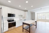 Located at Clubhouse Station in Waldorf, MD, this thoughtfully designed one-bedroom, one-bathroom residence offers a clean, modern aesthetic across a single floor. Warm hardwood flooring flows throughout the entire space, lending a cohesive and welcoming feel to every room.

The open-concept living area seamlessly connects the kitchen, dining, and living spaces, creating an airy and functional layout ideal for everyday living. The kitchen is a standout feature, outfitted with crisp white shaker cabinetry, white quartz countertops, a subway tile backsplash, and a full suite of stainless steel appliances including a French door refrigerator, electric range, built-in microwave, and dishwasher. Recessed lighting brightens the space, and an island provides additional prep and dining surface.

The bedroom is a comfortable retreat, featuring a vaulted ceiling detail, a large window that invites natural light and outdoor views, and a double-door closet. An additional closet provides extra storage convenience. The bathroom continues the home's modern palette with white cabinetry, a wide vanity with quartz countertop, a large mirror, and a shower/tub combination. In-unit laundry completes this well-appointed residence.