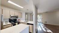 Located at 5505 Springhouse Dr in Pleasanton, CA, this well-appointed one-bedroom, one-bathroom residence offers a thoughtfully designed single-level layout. The open-concept living and kitchen area serves as the heart of the home, where wood-style flooring flows throughout and abundant natural light streams in through a sliding glass door that leads to a private outdoor patio. The living room features a tiled fireplace, adding warmth and character to the space.

The kitchen is equipped with stainless steel appliances, including a refrigerator, electric range, microwave, and dishwasher. Light wood cabinetry, white quartz countertops, a subway tile backsplash, and a peninsula with a sink complete the functional and modern kitchen design. An in-unit stacked washer and dryer adds everyday convenience.

The bedroom offers plush carpeting, a textured ceiling, a window for natural light, and a mirrored sliding-door closet providing ample storage. The bathroom is finished with wood-look flooring, a light wood vanity with a white countertop, brushed nickel fixtures, a large mirror, and a full tub-shower combination. Clean, neutral tones throughout the residence create a bright and cohesive ambiance.