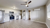 Located at 7820 Marty St in Overland Park, KS, this efficiently designed one-bedroom, one-bathroom unit offers a thoughtfully updated interior across a single floor. The open-concept kitchen and living area serves as the heart of the home, featuring light wood-look vinyl plank flooring, neutral gray walls, and a ceiling fan that enhances airflow throughout. The kitchen is well-appointed with white shaker-style cabinetry, granite countertops, a marble-look tile backsplash, and a full suite of stainless steel appliances including a refrigerator, range, microwave, and dishwasher. A ductless mini-split unit provides climate control in the living area. An adjacent utility room conveniently houses a stacked washer and dryer. The bedroom offers plush carpeting, a ceiling fan, a wall-mounted mini-split unit, and a window with blinds that brings in natural light. The bathroom is finished with a white shaker vanity, wood-look flooring, and a tub-shower combination clad in elegant marble-look tile surround with a built-in niche. The front entry features a windowed door and a large window, filling the living space with ample natural light and contributing to the home's clean, modern feel.