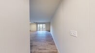 This three-bedroom, one-bathroom unit at 600 Kelly Ave in Wilkinsburg, PA offers a efficiently designed single-floor layout with consistent light wood-look flooring throughout. The open living room is the largest space in the unit, anchored by a sliding glass door that leads to a private balcony and fills the area with natural light, creating an airy, welcoming atmosphere.

The kitchen features light cabinetry with raised-panel doors, dark speckled countertops, white tile flooring, and stainless steel appliances including a refrigerator, dishwasher, and range. A pass-through window connects the kitchen to an adjacent room, enhancing the sense of openness between spaces.

The three bedrooms are outfitted with the same wood-look flooring and crisp white walls. The primary bedroom includes a sliding-door closet with a built-in rod and shelf. Additional bedrooms offer natural light through windows with outdoor views. A hallway connects all rooms efficiently.

The full bathroom includes a tiled tub-shower combination, tile flooring, a vanity with under-sink storage, and a large mirror, maintaining a clean, functional aesthetic throughout.