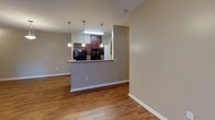 Located at 1000 Parker Cone Way in Greenville, South Carolina, this single-floor residence offers a well-organized layout with a cohesive, neutral color palette throughout. The open living area is finished with rich hardwood-style flooring and features a ceiling fan with light fixture, creating a comfortable and functional gathering space. A ceiling-mounted light and multiple electrical outlets add to the room's practicality.

The kitchen is a standout feature, anchored by a peninsula with a granite-style countertop and pendant lighting hanging above. Dark wood cabinetry provides ample storage, while black appliances — including a refrigerator and dishwasher — lend a modern contrast. A stainless steel sink completes this well-appointed cooking space.

The bedrooms are finished with plush carpeting and feature large windows fitted with horizontal blinds, allowing natural light to fill each room. The panel-style doors and clean white trim throughout the home add a crisp, finished look.

The bathroom is neatly appointed with light tile flooring, a rich dark wood vanity with a white countertop, a large mirror with overhead lighting, and a full tub-shower combination with chrome fixtures. The overall design of this home balances comfort and functionality, making it a practical and welcoming space in the Greenville area.