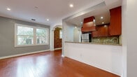 Located in the heart of West Hollywood on N Flores Street, this single-floor residence offers a thoughtfully designed layout that maximizes its comfortable footprint. Rich hardwood flooring flows throughout every room, lending warmth and continuity to the entire space.

The open-concept kitchen and living area serves as the heart of the home. The kitchen is well-equipped with rich cherry wood cabinetry, granite countertops, a stone tile backsplash, stainless steel appliances including a refrigerator and gas range, and a striking custom range hood. A peninsula counter separates the kitchen from the living area, ideal for casual dining or entertaining. Recessed lighting illuminates the space throughout.

The living room is highlighted by a distinctive exposed brick accent wall that adds character and texture, complemented by crown molding and a large window that draws in natural light and views of the surrounding neighborhood. An arched doorway connects to a secondary living area, which also features generous windows, a closet, and continued hardwood flooring.

The bathroom is finished with classic hex-tile mosaic flooring, subway tile in the tub-shower surround, a granite-topped vanity with white cabinetry, and polished chrome fixtures — balancing timeless style with practical function.