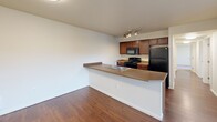 This 910 square foot apartment in Spokane, Washington, offers a well-designed single-floor layout with three bedrooms and two bathrooms. The primary bedroom, measuring 130 square feet, provides a spacious retreat. The open-concept design seamlessly integrates the kitchen and living areas, creating a sense of flow throughout the space. 

The kitchen features modern appliances, including a refrigerator and stove, with ample counter space and wooden cabinetry. The bathrooms boast contemporary fixtures, with at least one featuring a vanity with a large mirror and track lighting. 

Throughout the apartment, you'll find a cohesive design aesthetic with neutral walls, plush carpeting in the bedrooms, and durable wood-look flooring in high-traffic areas. Large windows in the bedrooms allow for plenty of natural light and offer views of the surrounding area. 

The apartment's efficient layout includes a hallway and closet space, ensuring both functionality and comfort. With its blend of modern amenities and thoughtful design, this Spokane apartment offers a comfortable and contemporary living space.