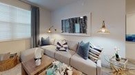 This single-floor residence offers a thoughtfully designed layout with a cohesive modern aesthetic throughout. The kitchen serves as a functional centerpiece, featuring white shaker-style cabinetry, granite countertops, a subway tile backsplash, and a full suite of stainless steel appliances, including a range, over-the-range microwave, French door refrigerator, and a wine cooler. Light wood-style flooring runs through the kitchen, which also includes a peninsula with an undermount sink and pendant lighting.

The living area provides a comfortable, intimate setting with natural light filtering through window treatments. Multiple bedrooms are present, each finished with plush carpeting, ceiling fans, and windows dressed with blinds and curtain panels. The primary bedroom connects to an en-suite bathroom featuring granite countertops, white cabinetry, tile flooring, and a glass-enclosed shower. A second full bathroom mirrors this clean aesthetic, offering a tub-shower combination with subway tile surround.

A dedicated in-unit laundry space houses a full-size washer and dryer with overhead shelving for added storage. The primary bathroom also leads to a walk-in closet, enhancing the overall functionality of the space.