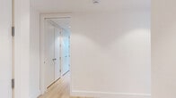 Located in Yonkers, NY, this thoughtfully designed 2-bedroom, 2-bathroom residence showcases modern architecture and high-end finishes across a well-appointed single floor. The open-concept living, dining, and kitchen area is an immediate highlight, anchored by dramatic floor-to-ceiling windows that frame breathtaking panoramic views of the Hudson River and the surrounding cityscape, flooding the space with abundant natural light. Light-toned hardwood flooring flows throughout the living areas and bedrooms, lending warmth to the clean, contemporary aesthetic.

The kitchen is a standout feature, boasting sleek flat-front cabinetry in warm wood tones and soft grey, pristine white quartz countertops, polished marble-look tile flooring, and a full suite of stainless steel appliances including a built-in microwave, electric range, and French door refrigerator. Both bedrooms are bright, well-proportioned spaces with light hardwood floors, crisp white walls, and wall-mounted climate control units. The primary bedroom enjoys sweeping river views through expansive windows.

The two bathrooms are finished in large-format grey tile, each featuring a floating wood-toned vanity, an illuminated medicine cabinet, and clean modern fixtures. One bathroom includes a soaking tub. The residence also features four closets, a dedicated laundry area, and an entrance hallway, completing this refined and functional home.