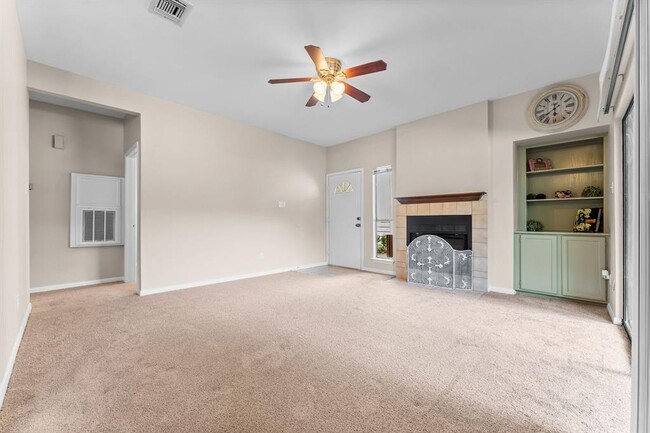 Living space with built-in shelves and storage, and a lovely fireplace - 3500 Tangle Brush Dr