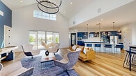 Located at 5103 Visionary Dr in Katy, TX, this thoughtfully designed single-floor community space offers a generous and well-appointed layout across its three distinct areas. The centerpiece is a dramatic living room distinguished by soaring vaulted ceilings, a bold blue accent wall, and large windows and sliding glass doors that flood the space with natural light and provide views of the outdoor amenity area. A wall-mounted TV, shuffleboard table, and a collection of curated artwork create an engaging and social atmosphere, while stylish swivel chairs and a patterned area rug anchor the seating arrangement. Wide-plank hardwood flooring flows seamlessly throughout the entire space, lending warmth and continuity. The kitchen and living area features a striking wall of bold blue shaker-style cabinetry contrasted by crisp white countertops and a herringbone-patterned tile backsplash. Stainless steel appliances, including a French door refrigerator and built-in microwave, complete the functional yet stylish kitchen. A separate lounge nook provides casual seating with round tables and comfortable chairs, ideal for informal gatherings. The dedicated office is a bright, professional conference-style room with a large rectangular table, upholstered rolling chairs, a modern pendant light fixture, and windows overlooking the outdoor area—making it well-suited for meetings or focused work sessions.