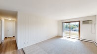 Located at 6417 Bridge Rd in Madison, Wisconsin, this single-floor residence offers two bedrooms and three bathrooms within a thoughtfully laid-out floor plan. The living room is a generous, light-filled space featuring plush carpet, a sliding glass door that opens to outdoor views of surrounding greenery, and a wall-mounted AC unit complemented by baseboard heating. A distinctive white vertical panel accent wall adds a clean, classic touch to the room's character.

The galley-style kitchen is efficiently designed with warm wood-toned cabinetry, dark countertops, a double stainless steel sink, and white appliances including a range and refrigerator. Durable wood-look flooring ties the space together. Adjacent pantry storage adds practical functionality.

Both bedrooms are carpeted and bright, benefiting from natural light through blinds-fitted windows and baseboard heating. The spacious primary bedroom offers ample room for furnishing. The three bathrooms include clean, tiled tub-shower combinations and vanities with granite-style countertops, wood cabinetry, and large mirrors. A dedicated closet provides additional storage. The overall aesthetic is clean, neutral, and move-in ready.