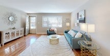 This single-floor residence offers a thoughtfully designed layout that balances comfort and functionality throughout. Warm hardwood flooring flows consistently across the living areas and bedrooms, lending a cohesive and inviting character to the entire space.

The living room is generously proportioned, filled with natural light streaming through large windows with blinds. The bright, neutral-toned walls provide a versatile backdrop, while the open feel of the room makes it ideal for both relaxing and entertaining.

Adjacent to the living room, the dining area features a pendant light fixture overhead and a window that brings in additional natural light, creating an pleasant setting for meals.

The kitchen is well-equipped with rich, dark wood cabinetry, stainless steel appliances including a gas range and refrigerator, and a striking granite-topped peninsula with an integrated sink — offering additional seating and workspace.

The two bedrooms are comfortable and well-sized, each featuring hardwood floors, neutral walls, windows for natural light, and closets with sliding or hinged doors providing practical storage.

The bathroom is finished with large-format tile surrounds in the tub and shower area, a granite-topped vanity, and a window for ventilation, presenting a clean and modern aesthetic throughout.