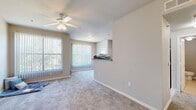 Located at 131 Aldine Bender Rd in Houston, TX, this single-story, one-bedroom, one-bathroom unit offers a practical and well-organized layout across its single floor. The living room features soft carpeting, a ceiling fan with light fixture, and large vertical-blind-covered windows that invite abundant natural light and offer outdoor views. A pass-through opening connects the living area to the kitchen, enhancing the open feel of the space. The kitchen is galley-style, finished with light tile flooring, warm wood cabinetry, granite-look countertops, and white appliances including a range, microwave, and refrigerator. A peninsula breakfast bar provides additional counter space and separation between the kitchen and living areas. The bedroom is generously sized, featuring plush carpet, a ceiling fan, and a large window with patio access, filling the room with natural light. Two closets serve the unit, including a walk-in closet outfitted with wire shelving for ample storage. The bathroom includes a tub-shower combination with accessibility grab bars, a vanity with granite-look counters, and tile flooring. A dedicated laundry area and a private patio round out this thoughtfully designed unit.