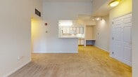 This single-floor residence at 20 Waterfall Dr in Canton, Massachusetts offers a well-organized layout designed for functional everyday living. The open living area is carpeted and bathed in natural light through large windows, with a door providing direct access to a private outdoor space such as a balcony or patio. Elevated ceilings and track lighting add a sense of openness to the main living space.

The kitchen is positioned at the heart of the home, accessible via a pass-through counter that connects it seamlessly to the living area. It features white cabinetry with warm wood trim, ample upper and lower storage, white appliances including a gas range, built-in microwave, and refrigerator, along with light countertops and tile flooring. A built-in desk area adjacent to the kitchen provides a convenient workspace.

The bedroom is generously sized with soft carpeting and a window framing views of surrounding greenery, creating a calm and private retreat. The bathroom includes a full tub and shower combination with tiled surround, a vanity with storage, and light tile flooring.

A dedicated laundry area includes a full-size washer and dryer with overhead shelving and additional cabinetry, providing practical storage and utility within the home.