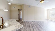 This single-story home in Orlando, FL offers a thoughtfully designed layout across three bedrooms and two bathrooms. The kitchen serves as a standout feature, showcasing white shaker cabinetry, granite-style countertops, a subway tile backsplash, stainless steel appliances, and wood-look flooring. A central island with a sink and pendant lighting above adds both functionality and visual appeal, with soaring ceilings lending an open, airy atmosphere to the space.

The bedrooms are finished with neutral-toned carpet and warm beige walls, with windows allowing natural light to filter in. The spacious primary bedroom connects to a walk-in closet outfitted with multi-tier wire shelving, offering generous storage. Secondary bedrooms include louvered bifold closet doors for additional organization.

Both bathrooms feature white vanities with granite-style countertops, wood-look flooring, and well-lit mirrors. One bathroom includes a full tub-shower combination with tiled surround. A dedicated laundry room accommodates a full-size washer and dryer side by side. A connecting hallway ties the layout together efficiently, creating a cohesive and practical living environment.