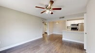 Located in Palm Harbor, Florida, this 2-bedroom, 2-bathroom residence offers a practical and well-appointed single-floor layout. The living room serves as the heart of the home, featuring wood-look laminate flooring, a ceiling fan, and a sliding glass door that opens to a private balcony with outdoor views — allowing abundant natural light to fill the space. An adjacent dining area with a pendant light connects seamlessly to the galley-style kitchen, which is outfitted with white cabinetry, light countertops, and stainless steel appliances including a range, microwave, and refrigerator. The primary bedroom is a comfortable retreat with plush carpeting, a ceiling fan, a window with natural light, and a closet with sliding panel doors. The second bedroom also features soft carpeting, a ceiling fan, and a window, making it well-suited as a guest room or home office. Both bathrooms are clean and functional, each featuring a tiled tub-shower combination, wood-look flooring, and bright white fixtures. One bathroom includes a vanity with a large mirror. Textured ceilings and neutral gray-toned walls are consistent throughout, lending the home a cohesive and move-in-ready aesthetic.