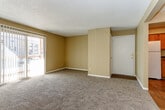Located at 1128 W 47th St in Kansas City, Kansas, this single-floor residence offers a practical and well-organized layout with consistent design elements throughout. The living room is a generously sized, open area finished with plush wall-to-wall carpeting and warm beige walls, complemented by a textured popcorn ceiling. A sliding glass door dressed with vertical blinds fills the space with natural light and provides access to the outdoors. Adjacent to the living area, the space opens into a dining or transitional zone that connects seamlessly to the kitchen, which features warm wood cabinetry, dark laminate countertops, and wood-look flooring. The galley-style kitchen is equipped with a white electric range, dishwasher, and a stainless steel sink, with ample upper and lower cabinet storage on both sides. The bedrooms are carpeted and feature neutral beige walls, textured ceilings, and windows with blinds that allow for natural light. The bathroom includes a wood-toned vanity with dark countertop, a wall-mounted mirror with overhead lighting, and a clean white tub and surround. Throughout the residence, a cohesive warm color palette and functional finishes create a comfortable and practical living environment.