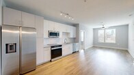 Located at 940 E Adams St in Jacksonville, FL, this well-appointed 2-bedroom, 2-bathroom residence offers a thoughtfully designed single-floor layout with a clean, modern aesthetic throughout. The open kitchen is a standout feature, showcasing white shaker-style cabinetry, granite countertops, a classic white subway tile backsplash, and a full suite of stainless steel appliances including a refrigerator, range, microwave, and dishwasher. Warm-toned hardwood-style flooring runs through the kitchen and living areas, creating a cohesive, contemporary feel. Both bedrooms are carpeted for comfort, painted in soft gray tones, and equipped with ceiling fans and window blinds that allow for natural light and outdoor views. The primary bedroom offers a generous footprint with ample room to furnish. Each bathroom continues the modern design language with white floating vanities, granite countertops, and glass-enclosed showers, complemented by the same hardwood-style flooring seen in the main living areas. Two closets provide convenient storage throughout the home. The unit also includes two dedicated closets, rounding out a practical and stylish living space in the heart of Jacksonville.