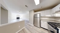Located at 601 Cabot Ct in Woodbury, NJ, this single-floor residence offers a clean, modern aesthetic with a thoughtfully designed open-concept layout. The living area is bright and spacious, showcasing light-toned luxury vinyl plank flooring, neutral walls, and a fireplace framed by dual windows that invite natural light. A door with blinds provides access to the outdoors, adding convenience and additional light to the space. The kitchen is well-appointed with crisp white shaker cabinetry, granite countertops, a classic subway tile backsplash, and a full suite of stainless steel appliances including a gas range, refrigerator, and dishwasher. A peninsula counter connects the kitchen seamlessly to the living area. The bedrooms are carpeted and generously sized, filled with natural light from large windows fitted with blinds. The bathroom features light vinyl plank flooring, a sliding glass enclosed shower-tub combination, and a vanity with understated finishes. A dedicated utility and laundry room houses a full-size washer and dryer alongside the water heater, offering practical in-unit convenience. The overall ambiance is fresh, neutral, and move-in ready, ideal for comfortable everyday living.