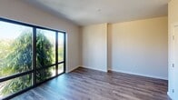 Located at 500 N Andrews Ave in Fort Lauderdale, FL, this well-appointed 2-bedroom, 1-bathroom unit offers a clean, modern aesthetic throughout. The open kitchen is a standout feature, showcasing sleek white cabinetry that extends to the ceiling, a marble-look tile backsplash, light stone countertops, and a full suite of stainless steel appliances including a French door refrigerator, electric range, dishwasher, and built-in microwave. Wood-look plank flooring runs seamlessly throughout the living areas and bedrooms, lending warmth and continuity to the space. The primary bedroom is a comfortable size and features a closet, while the second bedroom benefits from a large window that frames lush greenery, filling the room with natural light and bringing the outdoors in. The bathroom is finished with elegant marble-look tile surrounding a full soaking tub and shower combination, complemented by crisp white tile flooring and recessed lighting. A hallway connects the rooms efficiently, contributing to a practical and cohesive layout. The unit's neutral color palette and contemporary finishes create a bright, move-in-ready atmosphere ideal for those seeking modern urban living in the heart of Fort Lauderdale.