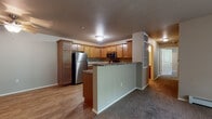 Located at 1711 Cottontail Ln in Reedsburg, Wisconsin, this single-floor unit offers a functional and practical layout designed for comfortable everyday living. The kitchen serves as a central feature of the space, outfitted with warm honey-toned wood cabinetry extending to the ceiling, dark granite-style countertops, and a full suite of stainless steel appliances including a refrigerator, range, microwave, and dishwasher. Durable wood-look flooring runs throughout the kitchen, while a peninsula with a breakfast bar provides a natural transition into the adjacent living area. The living room is generously sized, featuring neutral carpet, baseboard heating, and access to natural light through a sliding door with vertical blinds.

The bedroom is well-proportioned, carpeted, and includes a ceiling fan with light fixture and a window for natural light. Two bathrooms serve the unit — one featuring a walk-in shower stall, wood-toned cabinetry with granite-style counters, and wood-look flooring, while the second offers similar finishes with additional wall-mounted storage. A hallway connects the private areas of the unit efficiently. The attached garage provides enclosed parking and additional storage space with an automatic opener.