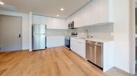 Located at The Sanctuary in West Sacramento, CA, this thoughtfully designed single-story residence offers three bedrooms and two bathrooms within a clean, modern aesthetic. The open-concept layout connects the kitchen and living area seamlessly, creating a bright and airy atmosphere enhanced by recessed lighting and light-toned hardwood flooring that flows throughout the home. The contemporary kitchen is a standout feature, equipped with stainless steel appliances including a range, microwave, dishwasher, and refrigerator, complemented by sleek white flat-panel cabinetry, a subtle tile backsplash, and light countertops. The living area extends naturally from the kitchen, bathed in natural light from large windows with views of the surrounding community. The spacious primary bedroom features large windows, a door to the exterior, and a generous closet with built-in shelving. The additional bedrooms are well-proportioned with warm hardwood flooring and clean white walls. Both bathrooms continue the home's modern palette, finished in white with wood-look flooring, and one includes a full bathtub with a floating white vanity. The overall ambiance is bright, minimal, and move-in ready, reflecting a fresh, contemporary design sensibility.