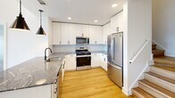 Located at 1 Samuel Peterson Dr in Titusville, NJ, this two-story home offers a thoughtfully designed layout across two floors. The main level is anchored by a bright, open-concept living, dining, and kitchen area finished with light hardwood flooring that runs throughout. The kitchen is well-appointed with white shaker cabinets, a herringbone tile backsplash, stainless steel appliances, and a granite-topped island with pendant lighting and a matte black sink — a stylish centerpiece for the space. Large windows and a glass door flood the living area with natural light and offer views of the surrounding neighborhood. The main floor also includes an entrance, a laundry room, and abundant closet storage. Upstairs, the primary bedroom is generously sized, featuring hardwood floors, tall ceilings, and expansive windows with neighborhood views. The second bedroom is carpeted and bright with a ceiling fan. A loft space adds flexible utility. All three bathrooms are finished with classic black-and-white hexagonal tile flooring, granite countertops, warm wood vanities, and matte black fixtures, lending a cohesive modern aesthetic throughout. With eight closets distributed across the home, storage is plentiful. This home presents a clean, contemporary design with high-quality finishes at every turn.