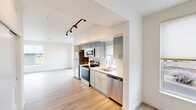 Located at 713 E 29th Ave in Spokane, WA, this well-designed one-bedroom, one-bathroom residence offers a thoughtfully laid-out floor plan that maximizes every inch of its space. Light-toned hardwood flooring runs throughout the unit, creating a cohesive and airy feel across all rooms.

The kitchen and living room share an open-concept layout, allowing natural light to flow freely between the two spaces. The kitchen is equipped with a full suite of stainless steel appliances, including a refrigerator, electric range, over-the-range microwave, and dishwasher. Shaker-style cabinetry in a muted gray tone pairs cleanly with white quartz countertops, while track lighting above adds both function and a modern touch. A window above the sink invites additional natural light into the cooking space.

The bedroom is a comfortable, well-proportioned room featuring a large window that brings in outdoor views and natural light. A dedicated walk-in closet with wire shelving along two walls provides generous storage.

The bathroom maintains the same clean aesthetic as the rest of the unit, with gray shaker-style cabinetry, a white vanity top, a framed mirror, and hardwood-style flooring. The overall ambiance of the unit is bright, modern, and move-in ready, reflecting contemporary residential design.
