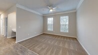 Located at 1932 Stanton Rd in East Point, GA, this single-story, 3-bedroom, 2-bathroom home offers a well-designed layout with a comfortable and functional flow throughout. The open-concept living, dining, and kitchen area forms the heart of the home, featuring wood-look flooring, crown molding, and a pendant light fixture over the dining space. The kitchen is equipped with stainless steel appliances—including a range and refrigerator—white shaker-style cabinetry, a peninsula with a sink, and light countertops, all tied together with matching wood-look flooring. The three bedrooms are carpeted and finished in neutral tones, each featuring ceiling fans. The primary bedroom is generously sized and includes a walk-in closet with wire shelving. Two additional bedrooms offer ample space and natural light through large windows. The two bathrooms are outfitted with wood-look tile flooring, white cabinetry, and full tub-shower combinations. A dedicated laundry room with washer and dryer hookups adds everyday convenience, complemented by three closets and a utility room for additional storage throughout the home.