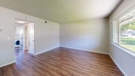 This two-story home in Fairfield, CA offers a well-organized layout across two floors, thoughtfully designed to maximize functionality. The main level features a bright living room with warm wood-look hardwood flooring, neutral walls, and a textured ceiling, with a large picture window that frames views of the surrounding neighborhood and mature trees, filling the space with natural light. The compact kitchen is efficiently arranged and well-appointed with white cabinetry, light quartz-style countertops, stainless steel appliances including a gas range, microwave, dishwasher, and refrigerator, as well as an in-unit washer — a practical and convenient feature. The upper floor hosts two bedrooms, including a generously sized primary bedroom with a sliding-door closet and access to natural light through wide windows overlooking tree-lined surroundings. The second bedroom is equally comfortable, featuring the same warm flooring found throughout the home. Three bathrooms serve the residence, including one with a full tub-and-shower combination with white tile surround and brushed nickel fixtures. Consistent wood-look flooring, clean white trim, and a neutral color palette throughout lend the home a cohesive, move-in-ready feel.
