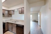 Located at 456 W Meadow Dr in Tulare, California, this two-story, 2-bedroom, 2-bathroom home offers a practical and well-organized layout spread across two floors. The main level houses a combined kitchen and living area, where the kitchen stands out with rich dark-stained cabinetry, granite-style countertops, black appliances including a gas range and dishwasher, and a stainless steel double sink. The living area features light wood-look flooring and a sliding glass door that opens directly to a private fenced outdoor space, allowing natural light to fill the room. Both floors are connected by a staircase, with a hallway providing smooth circulation throughout. The two bedrooms are located on the upper floor, each offering wood-look flooring, neutral walls, and closet storage. The primary bedroom provides a comfortable and well-proportioned retreat. Both bathrooms are finished consistently with granite-topped dark wood vanities and wood-look tile flooring; one bathroom includes a full shower-tub combination and a window for natural ventilation. Throughout the home, a clean, neutral color palette and cohesive finishes create a bright, move-in-ready atmosphere suited for everyday living.