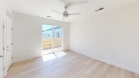 Located at 500 Maury St in Richmond, Virginia, Studio 619 is a thoughtfully designed studio that maximizes its intimate footprint with modern finishes and efficient use of space. The open living area features light wood-tone flooring and crisp white walls that create a bright, clean aesthetic throughout. A ceiling fan and sliding glass door lead to a private balcony, flooding the space with natural light and offering views of the surrounding neighborhood.

The kitchen is a standout feature, outfitted with slate-blue cabinetry extending to the ceiling for ample storage, white countertops, and a full suite of stainless steel appliances including a refrigerator, electric range, built-in microwave, and dishwasher. A single-basin stainless sink with a matte black faucet anchors the countertop, completing the contemporary look.

The bathroom maintains the same modern sensibility, with a clean white tub-shower combination accented by a curved matte black curtain rod, a wall-mounted vanity with an integrated sink, and a large mirror with built-in lighting. Light tile flooring ties the space together seamlessly. Overall, Studio 619 offers a well-appointed, move-in-ready layout ideal for those seeking functional, stylish urban living in Richmond.