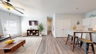 This thoughtfully designed 2-bedroom, 2-bathroom residence offers a cohesive, modern aesthetic throughout its single floor. The open living area welcomes you with warm wood-look flooring, soft neutral walls, and a ceiling fan overhead, creating a bright and comfortable atmosphere. A dedicated hallway connects the living spaces to the bedrooms and bathrooms, providing an efficient and organized layout.

The kitchen is a standout feature, showcasing white shaker cabinetry, granite countertops, a classic subway tile backsplash, and a full suite of stainless steel appliances including a range, microwave, dishwasher, and refrigerator. A central island with bar seating adds both functionality and a casual dining option.

Both bedrooms are carpeted for comfort, with large windows that invite natural light and ceiling fans for year-round climate control. The primary bedroom offers a generous footprint, while the second bedroom provides versatility for guests or a home office.

The two bathrooms mirror the home's clean, contemporary style, each featuring white vanity cabinetry, quartz-style countertops, framed mirrors, and tub-shower combinations. Consistent wood-look flooring ties each bathroom seamlessly to the rest of the residence, resulting in a polished, unified look throughout.